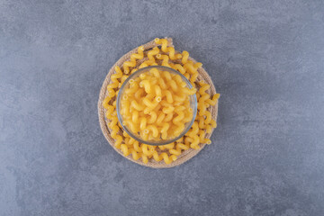 Raw dry macaroni in glass bowl