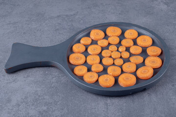Sliced carrots in a pan, on the marble background