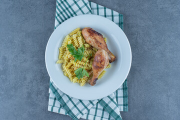 Delicious fusilli with chicken legs on white plate