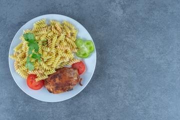 Roasted chicken and fusilli on white plate