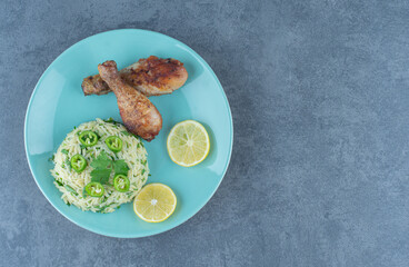 Portion of rice with chicken legs on blue plate