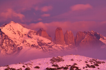 Winter twilight lanscape from Patagonia moutains with snow. Laguna Amarga, Torres del Paine National Park, Chile. Pink blue evening sky. Traveling in Chile,  hills in Torres del Paine NP.