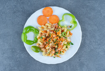 Tasty pasta with chopped vegetables on white plate