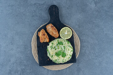 Portion of rice with chicken nuggets on black board