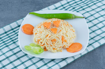 Steamed rice with chopped carrots on white plate