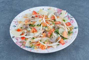Boiled dough with chopped vegetables on colorful plate