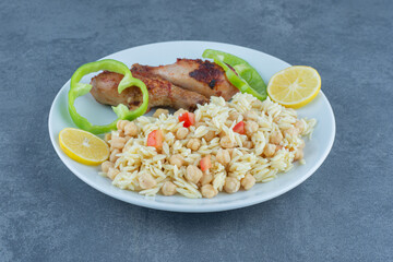 Roasted chicken and rice with chickpeas on white plate