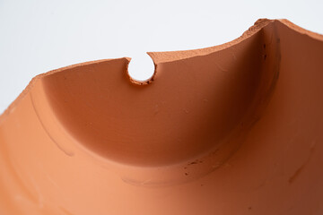 Broken terracotta pot close up on isolated white background. Manufactured defect. Shipment risk.