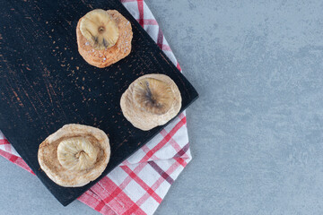 Dried figs on the cutting board, on the towel, on the tea towel, on the marble background