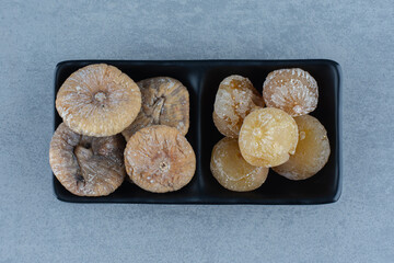 Two kinds of dried fruit in the bowl, on the marble background