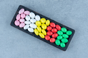 Toothsome gums in the wooden tray , on the marble background