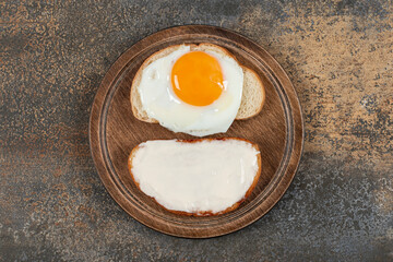 Toast with cream cheese and egg on wooden board
