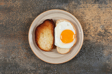Toast and bread with egg on ceramic plate