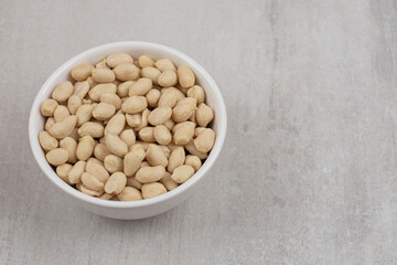 Bunch of peeled peanuts in white bowl