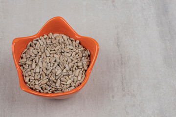 Roasted sunflower seeds in orange bowl