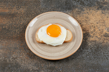 Toast bread with egg on ceramic plate