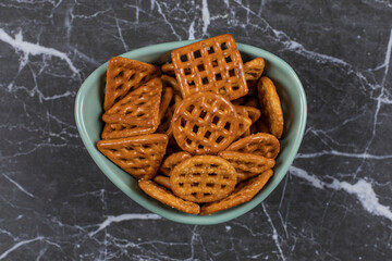 Delicious salty crackers in blue bowl