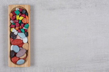 Colorful various stone candies on wooden plate