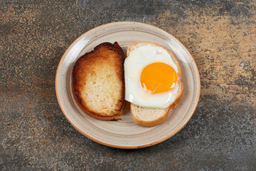 Toast and bread with egg on ceramic plate