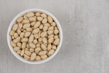 Bunch of peeled peanuts in white bowl
