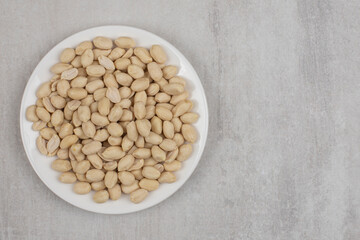 Delicious peeled peanuts on white plate