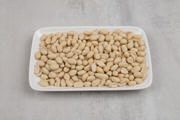 Bunch of peeled peanuts on white plate