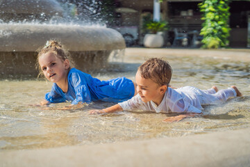 Happy children plays in the street fountain