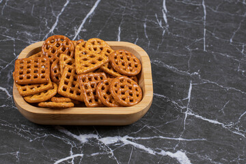 Delicious salty crackers on wooden plate