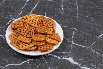 Delicious salty crackers on white plate