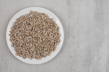 Pile of sunflower seeds on white plate