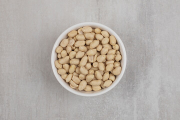 Bunch of peeled peanuts in white bowl