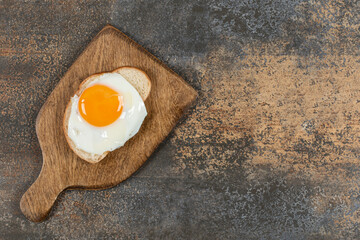 Toast bread with egg on wooden board