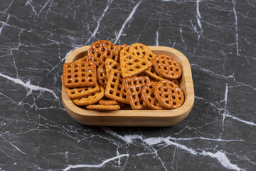 Delicious salty crackers on wooden plate
