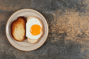 Toast and bread with egg on ceramic plate