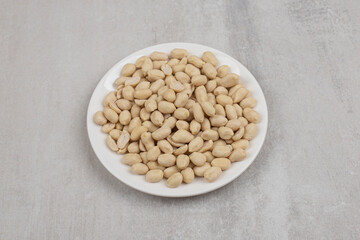 Delicious peeled peanuts on white plate