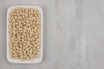 Bunch of peeled peanuts on white plate
