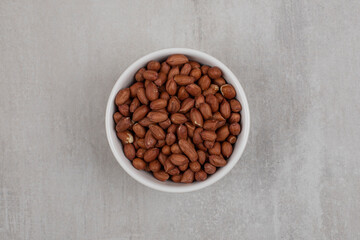 Heap of fresh peanuts in white bowl
