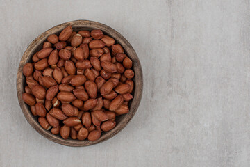 Heap of fresh peanuts in wooden bowl