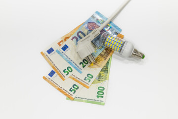 Electric plug, light bulb, and euro banknotes. Concept of rise in energy bill prices
