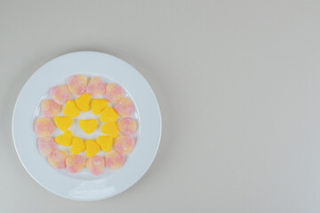 A white plate full of colorful heart shaped jelly candies