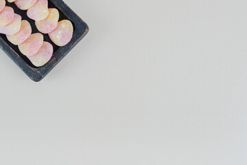 A dark wooden board full of heart shaped jelly candies