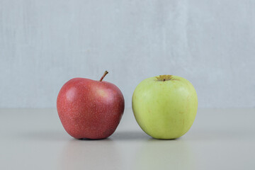 Red and green fresh apples on gray background