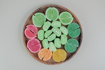 A wooden board full of colorful sugary marmalades