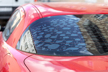 Rear car window with old adhesive defective dark sunproof tint film in air bubbles. Mistake wrong...