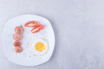Sliced sausages and egg on white plate