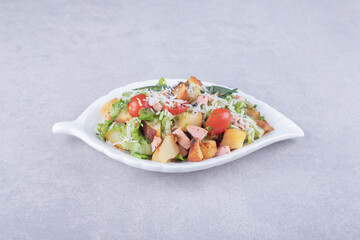 Sliced fried sausages and lettuce in white bowl