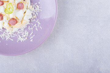 Fototapeta na wymiar Grated cheese and egg with sausages on purple plate