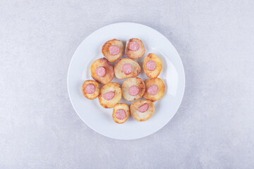 Smoked sausages with fried potato on white plate