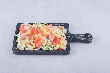 Sliced tasty sausages with fresh salad on black board