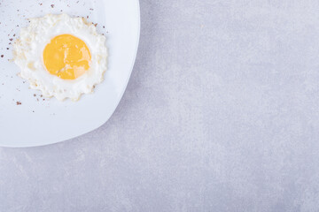 Homemade fried egg on white plate